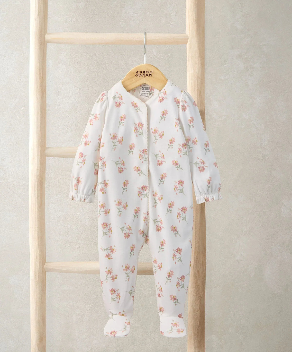 Daisy-print sleepsuit with long sleeves and footed legs, white with pastel flowers