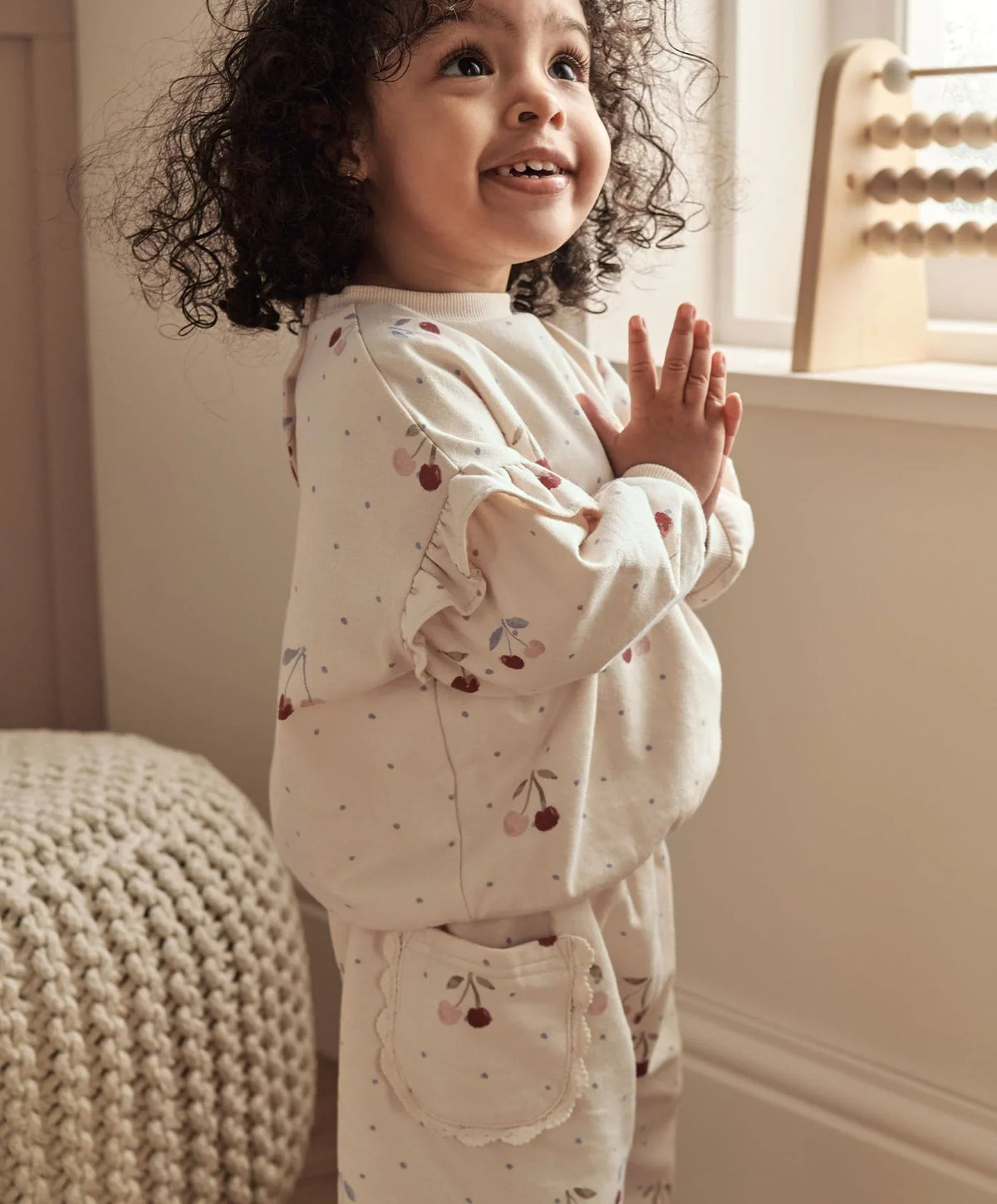 Cherry sweatshirt worn by child, cream with cherry print, long sleeves