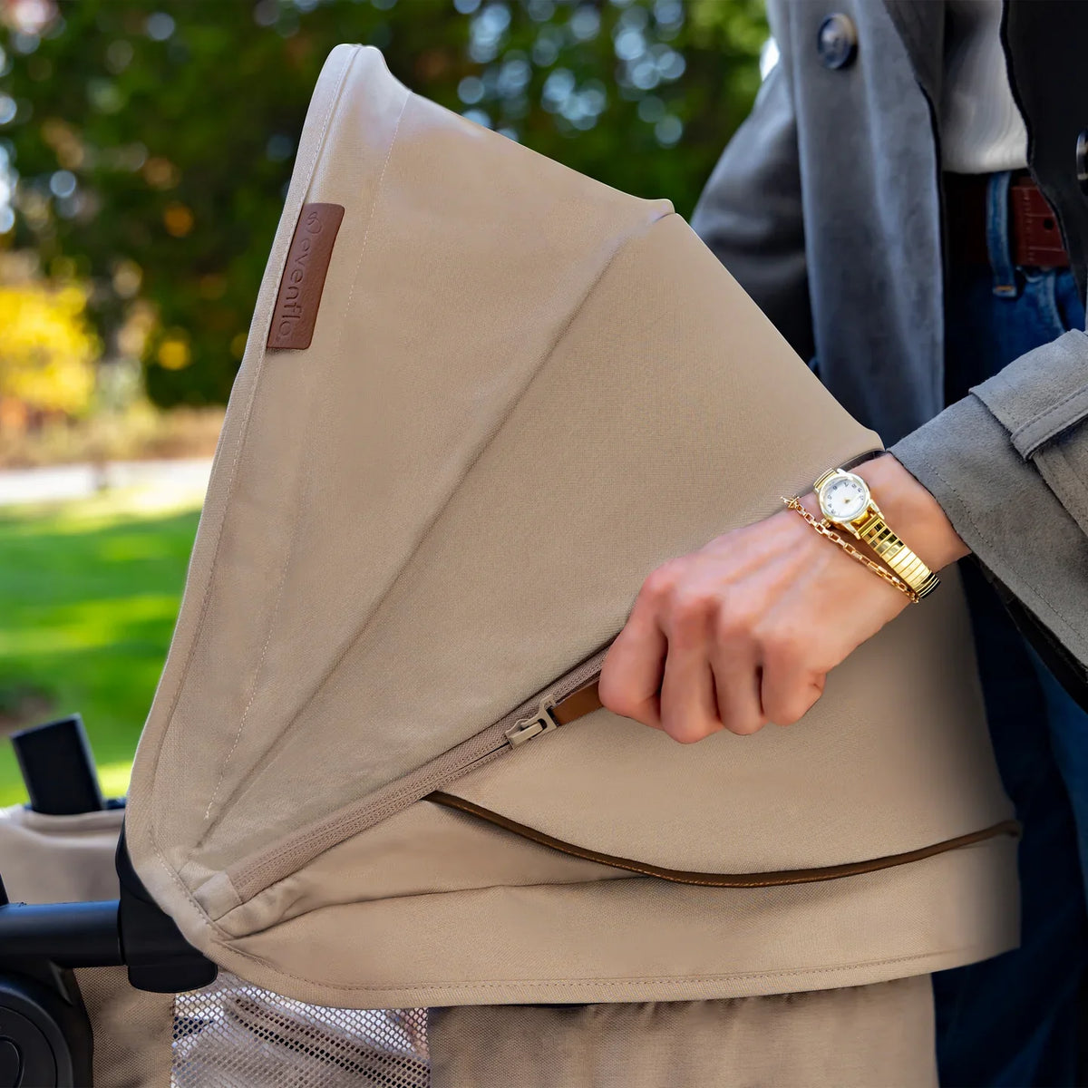 Baby stroller canopy side panel and armrest, light beige fabric.