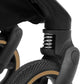 Black stroller suspension joint with metal spring detail, close-up