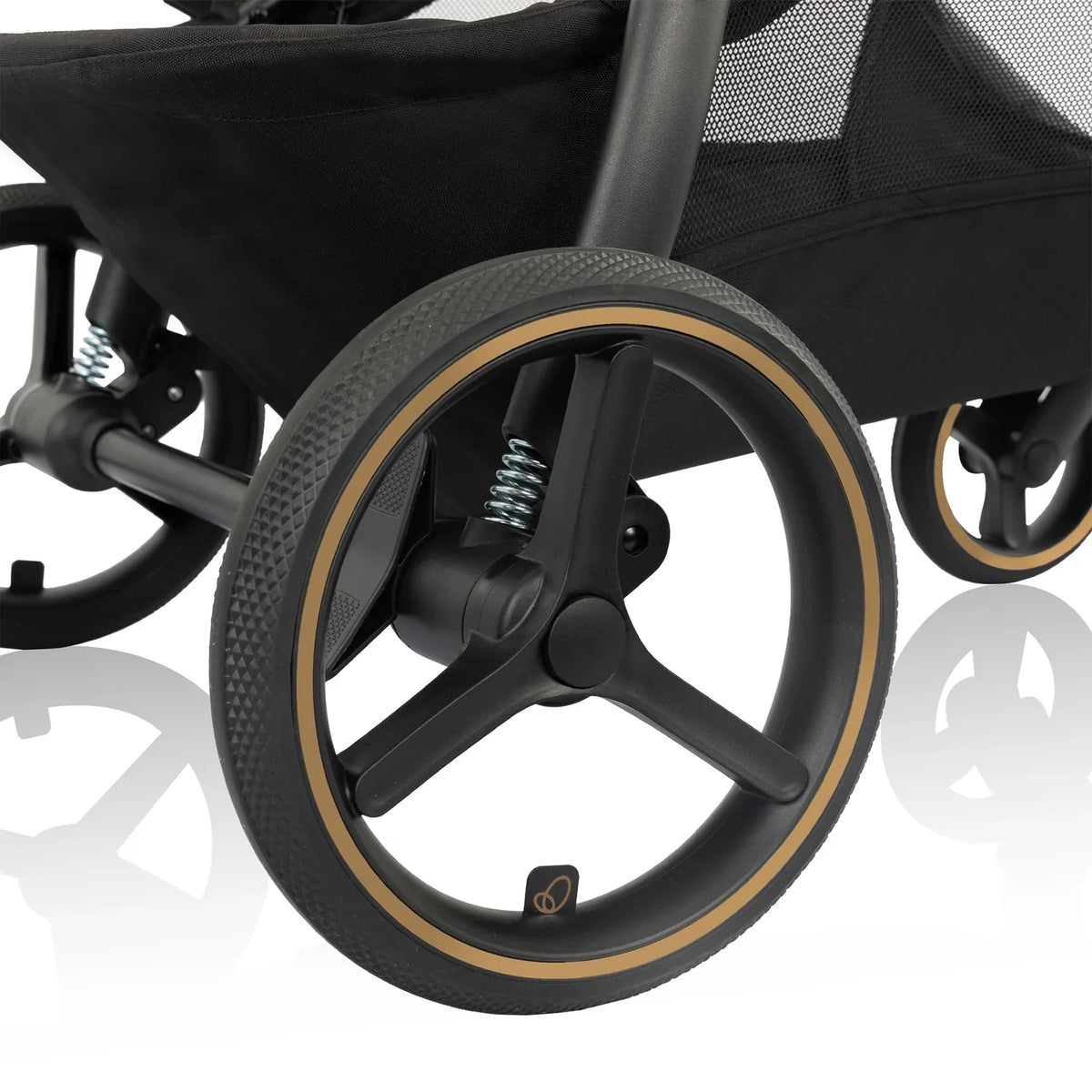 Stroller front wheel with gray tire and gold-trimmed rim.