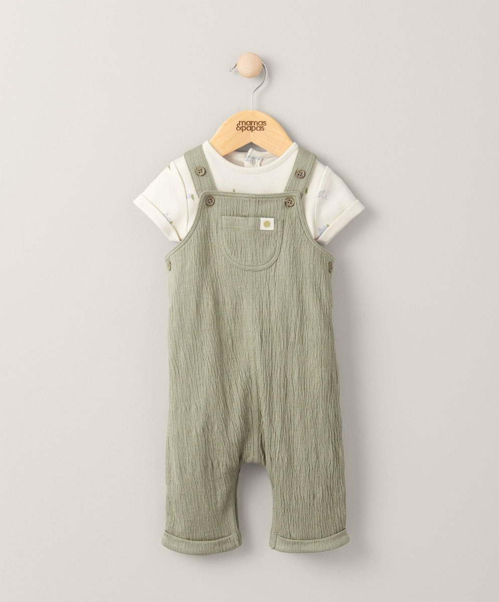 Kids bodysuit and dungarees outfit set: white T-shirt bodysuit with green overall straps.