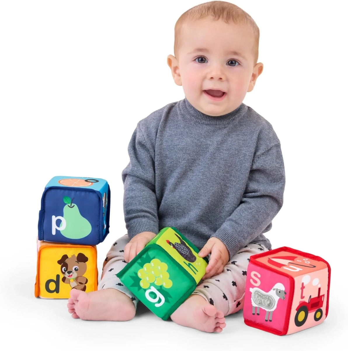 Soft block cubes in blue, green, orange, and red on baby lap
