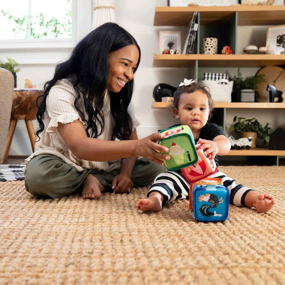 Baby playing with multicolor soft blocks cubes while sitting on a rug