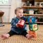 Baby holding multicolor soft blocks cubes with letters and animal prints