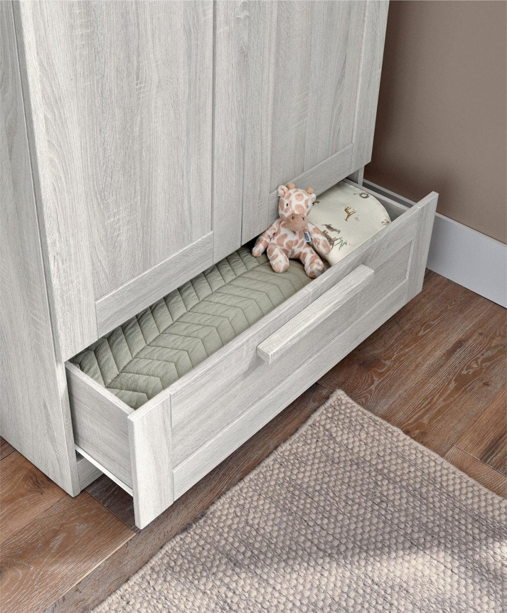 Nursery wardrobe storage drawer open with quilted liner, light nimbus white cabinet