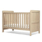Light oak cotbed with paneled ends and vertical slat mattress rails