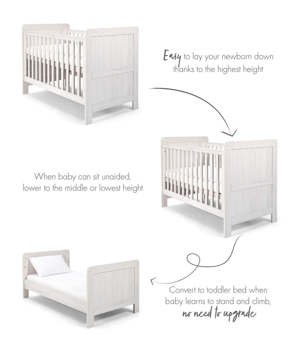 White cotbed with vertical slats, squared end panels, and low base position