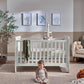 Light gray cotbed with vertical slat rails and raised end panels, nursery setup