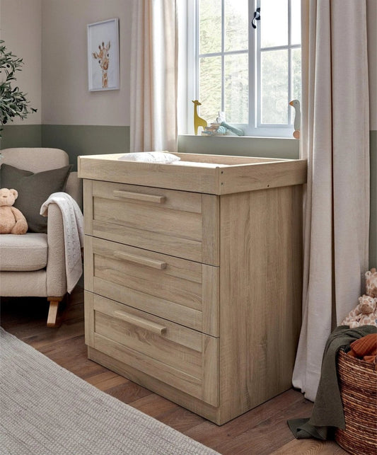 Light oak dresser changer with changing top and three drawers in a nursery
