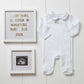 White baby scan photo frame wall set with ultrasound print and a decorative announcement plaque.