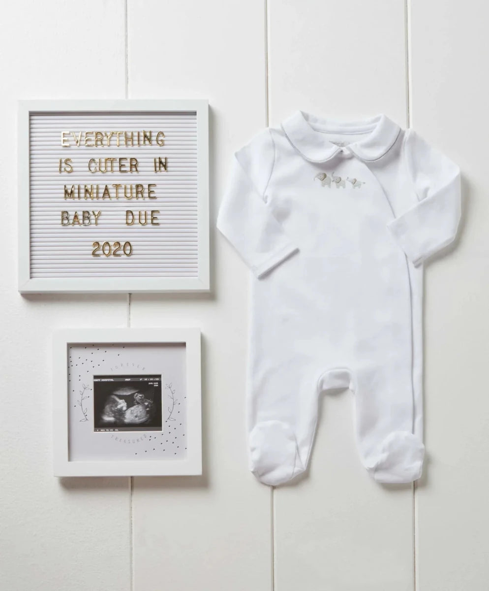 White baby scan photo frame wall set with ultrasound print and a decorative announcement plaque.