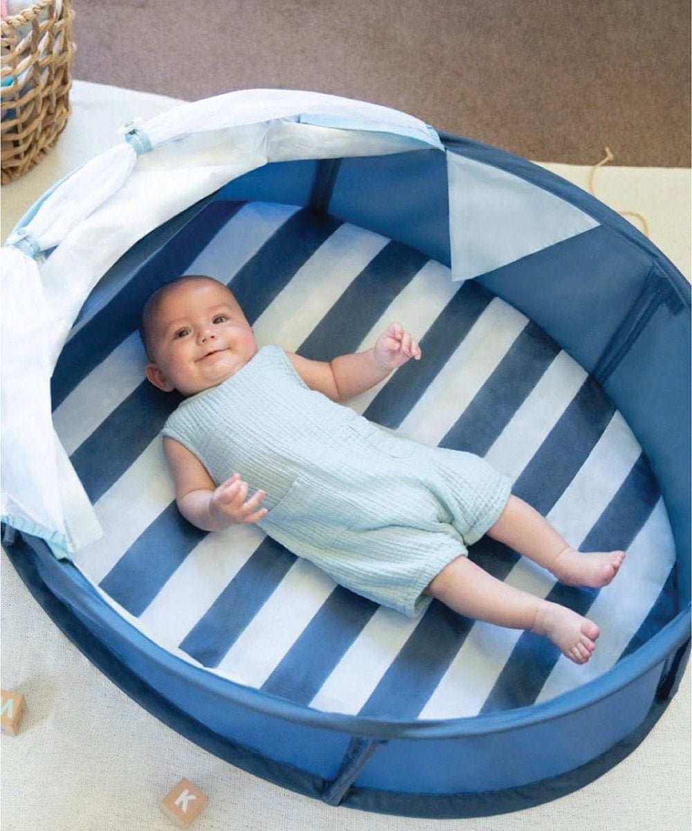 Blue-and-white striped play mat inside navy pop-up tent with open mesh sides