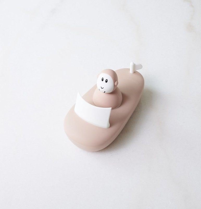 Pink bath boat with white toilet seat and smiling monkey bath toy