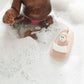 Pink monkey bath toy in water with white seat on curved bath boat