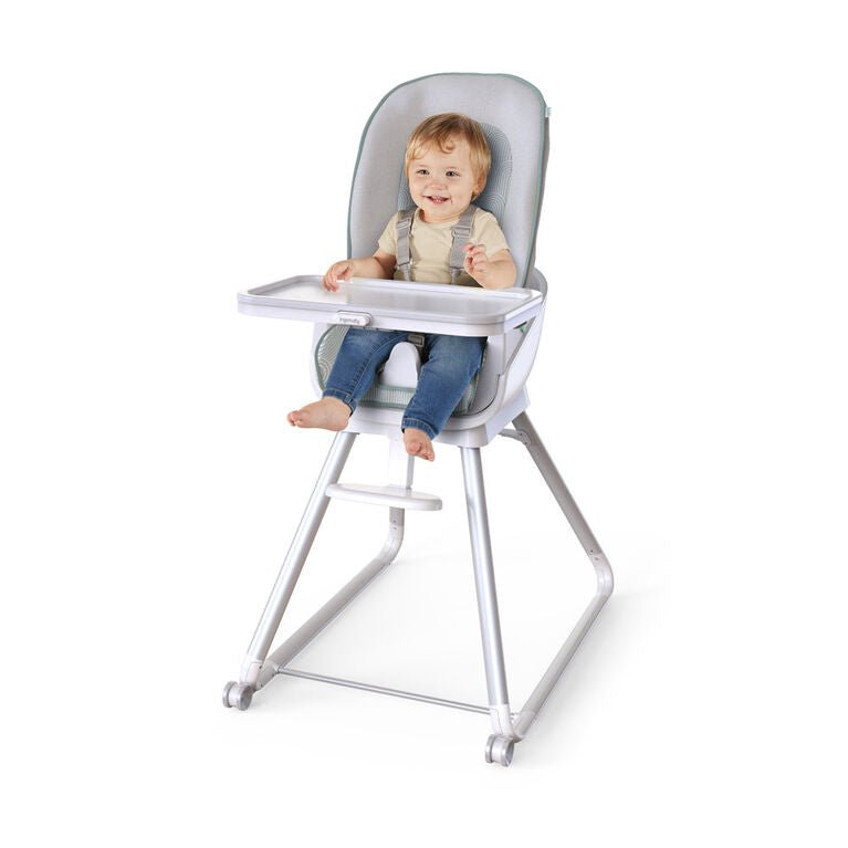 Gray high chair with clear tray and padded seat, child seated with legs supported