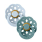 Pair of BIBS flower pacifiers in light blue and teal, with gold center rings