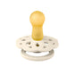 Pacifier with yellow nipple and white round floral shield, with gold center ring
