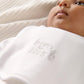 White baby bib front close-up with embroidered “Born 2025” text and motif