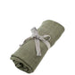 Khaki ribbed knitted blanket with tied fabric bow, rolled