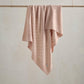 Pink pointelle baby blanket with allover scattered pattern, draped