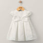 White bow dress with cap sleeves and waist tie, pleated skirt
