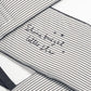 Striped baby bed bumper with music notes and stars, navy-stitched edges