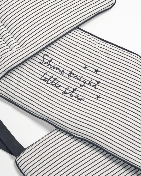 Striped baby bed bumper with music notes and stars, navy-stitched edges