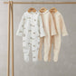 Footed baby sleepsuit set of three with bunny prints in pastel colors on hangers