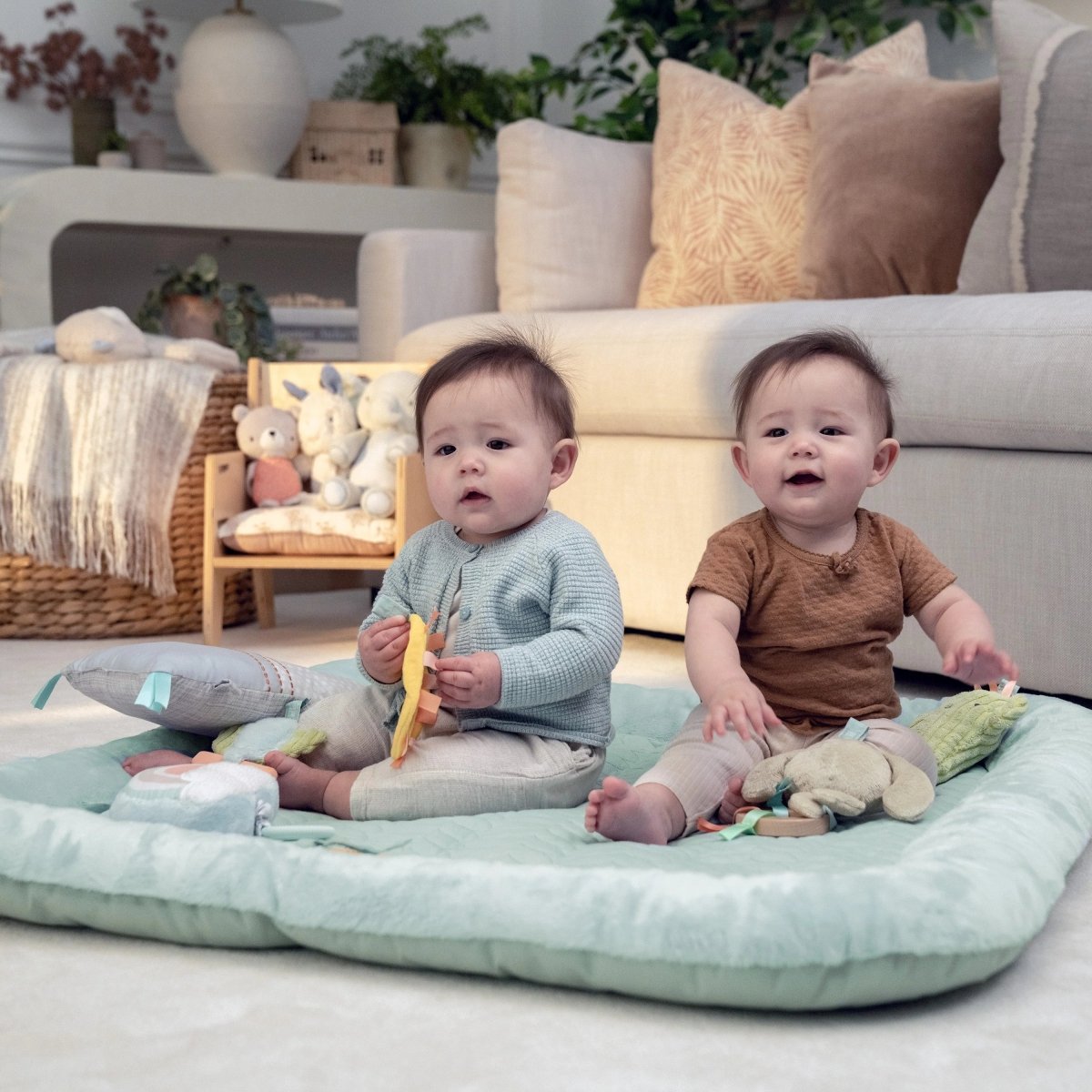 Plush baby activity gym with padded mat and hanging toys, used by infants