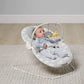 Bouncing cradle with gray-and-white seat, infant lying back, star toy in view