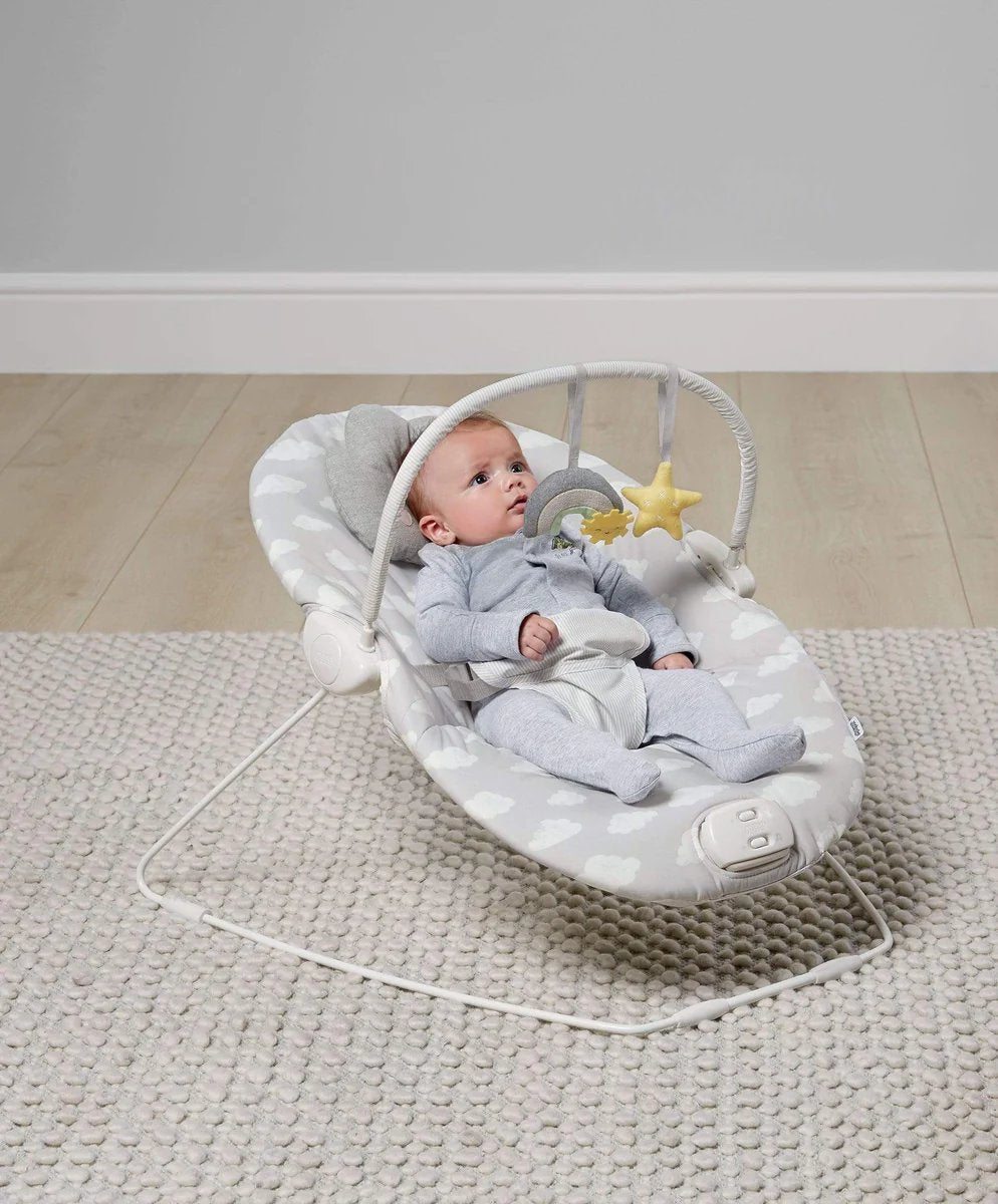 Bouncing cradle with gray-and-white seat, infant lying back, star toy in view