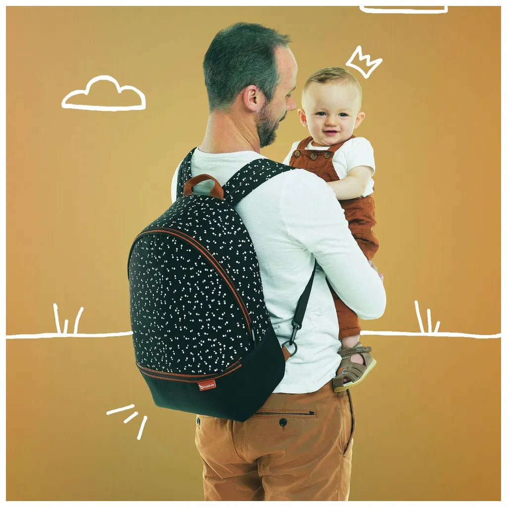 Diaper backpack worn on back, black speckle fabric with brown trim and front pocket