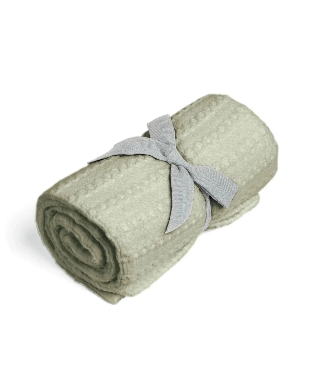 Cellular blanket in sage green, rolled bundle tied with fabric bow