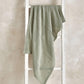 Cellular blanket in sage green, draped with textured waffle knit