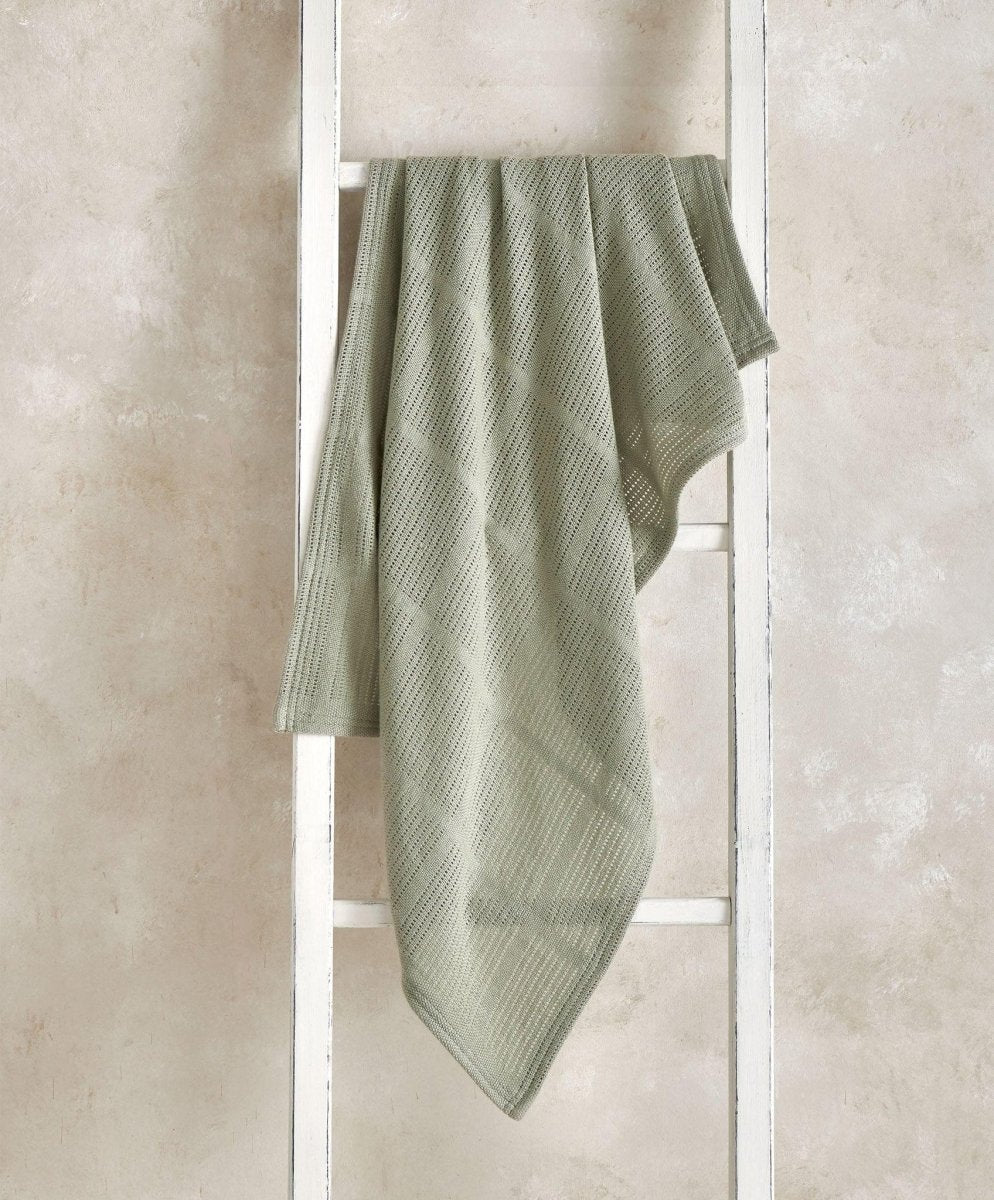 Cellular blanket in sage green, draped with textured waffle knit