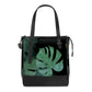 Black changing bag with green tropical leaf print, top handles and front zipper pocket