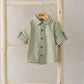 Green-and-white check button-up shirt with short sleeves and front buttons