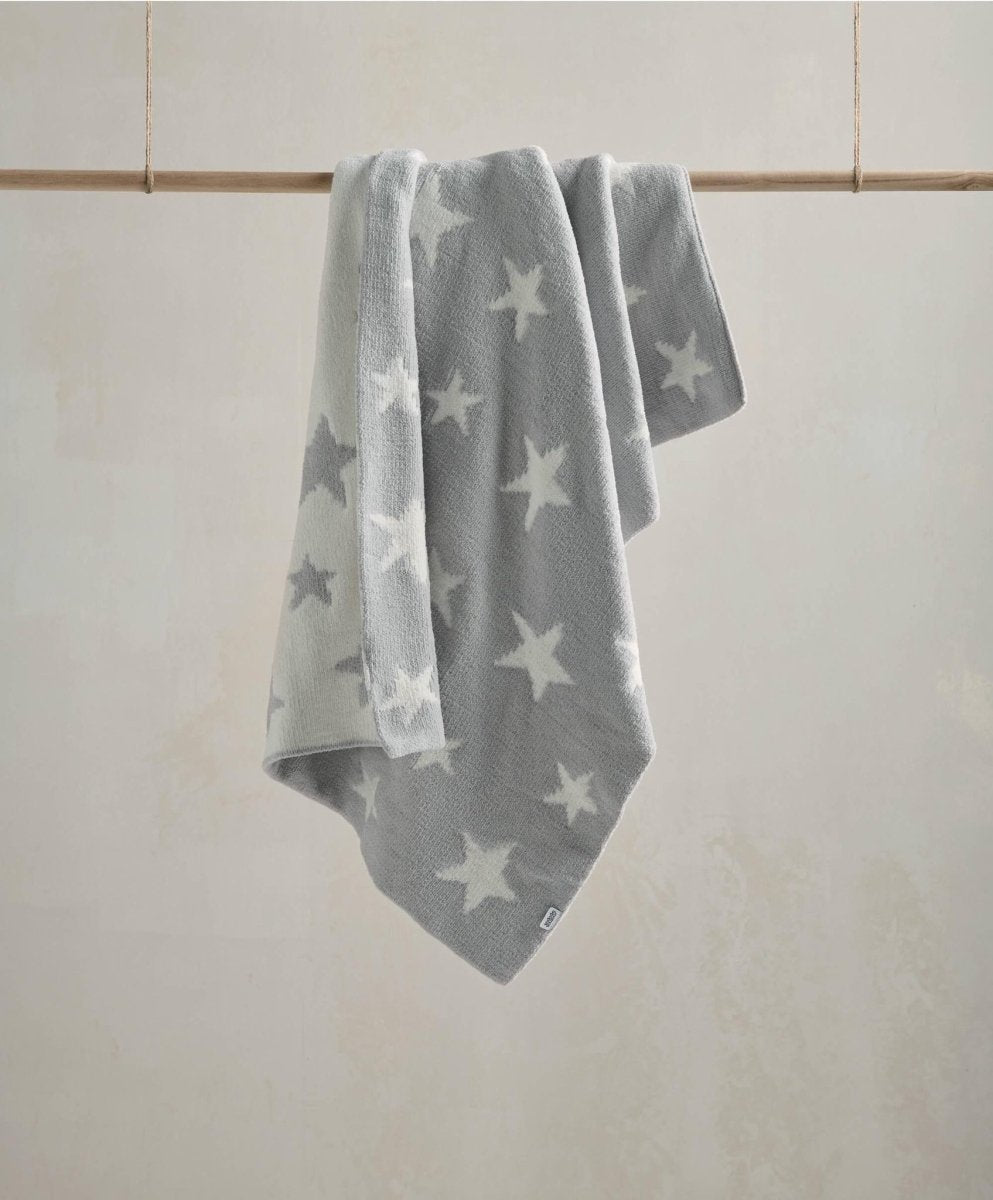 Chenille blanket in light grey with white star pattern, draped view