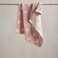 Pink chenille blanket with white star pattern, draped