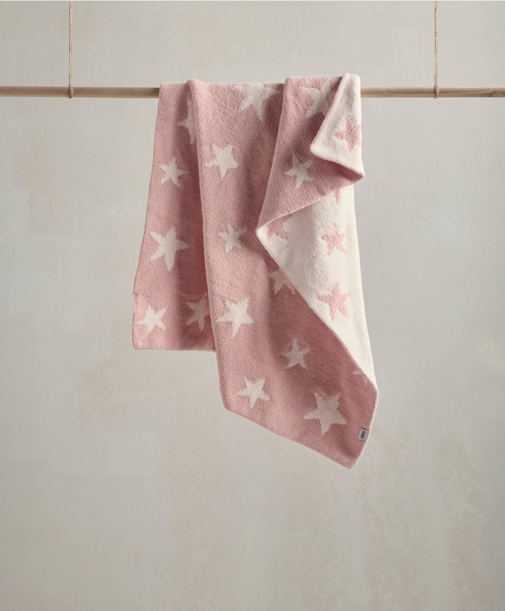 Pink chenille blanket with white star pattern, draped