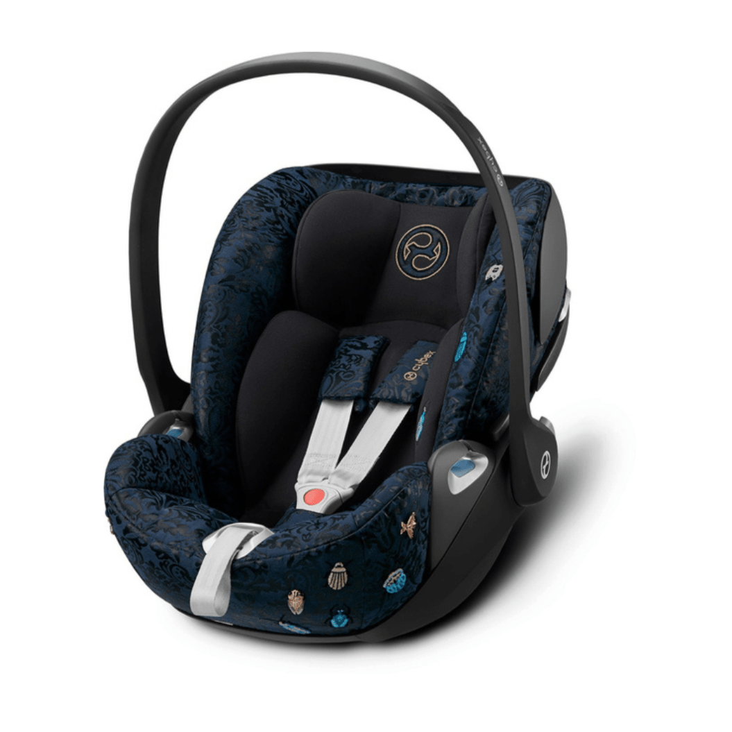 Rear-facing baby car seat with dark blue patterned interior, black shell, side handle