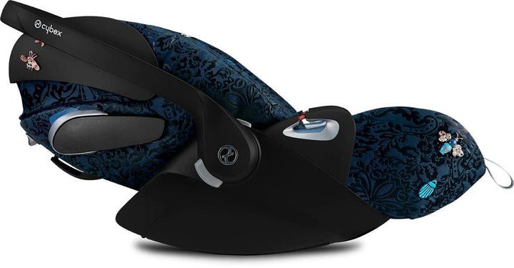 Baby car seat with dark blue patterned seat and black base, side carry handle and harness
