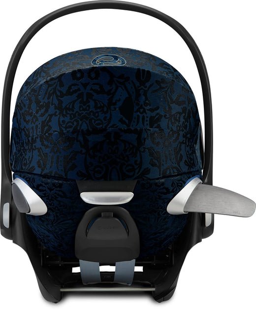 Infant car seat with dark blue patterned headrest cover and black safety straps