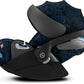 Baby car seat on black base, dark blue patterned canopy with side handle and footrest
