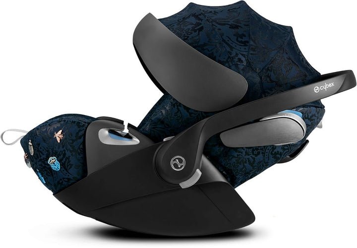 Baby car seat on black base, dark blue patterned canopy with side handle and footrest