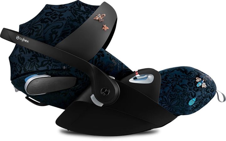 Baby car seat with dark blue patterned seat and black base, five-point harness visible
