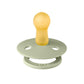 Sage green baby pacifier with round shield and yellow nipple