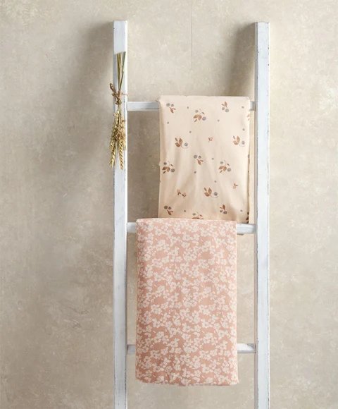 Cotbed fitted sheet set on cot rails, pale floral and blush floral fitted sheets