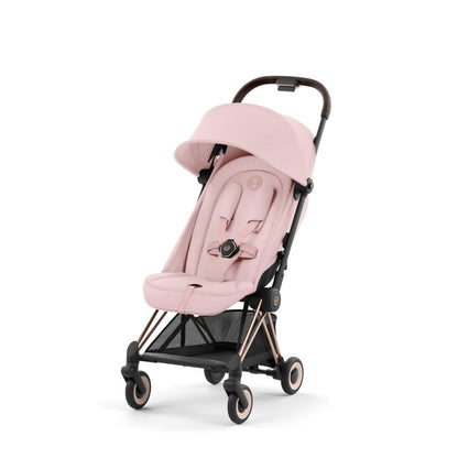 Ultra-compact stroller with pink canopy and seat, rose-gold frame, front-left view